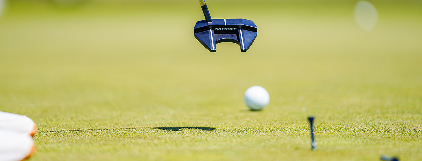 zoomed in view of golf ball being hit on an outdoor course